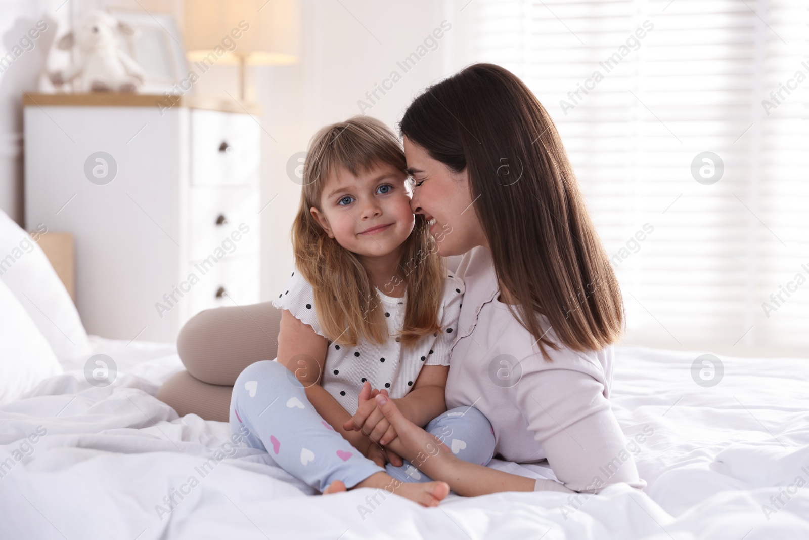 Mother and daughter on bed at home Photo of Mother and daughter on bed at home