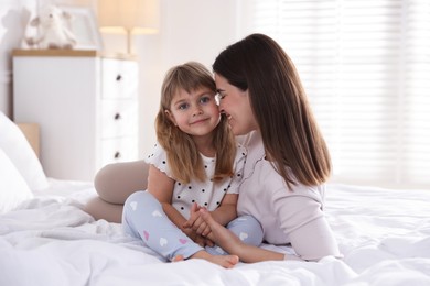 Photo of Mother and daughter on bed at home