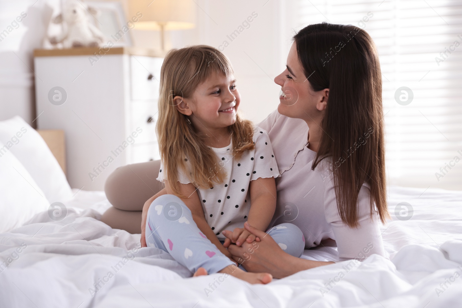 Mother and daughter on bed at home Photo of Mother and daughter on bed at home