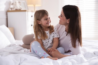 Photo of Mother and daughter on bed at home