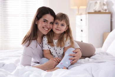 Photo of Mother and daughter on bed at home
