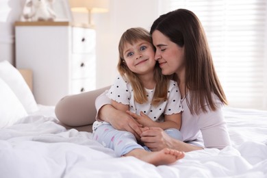 Photo of Mother and daughter on bed at home