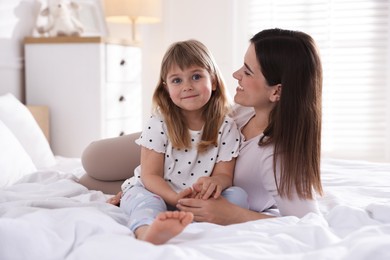 Photo of Mother and daughter on bed at home