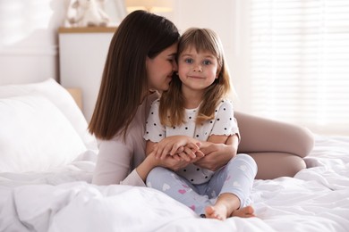 Photo of Mother and daughter on bed at home