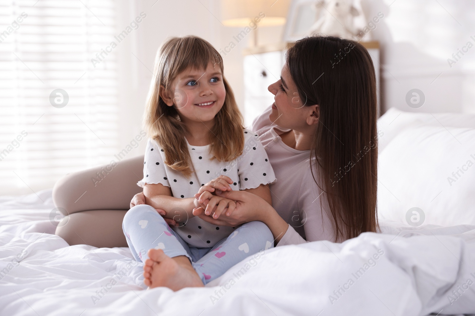 Mother and daughter on bed at home Photo of Mother and daughter on bed at home