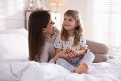 Photo of Mother and daughter on bed at home
