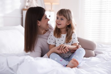 Photo of Mother and daughter on bed at home