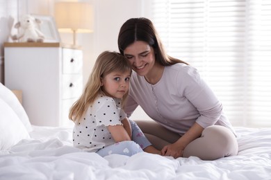 Photo of Mother and daughter on bed at home