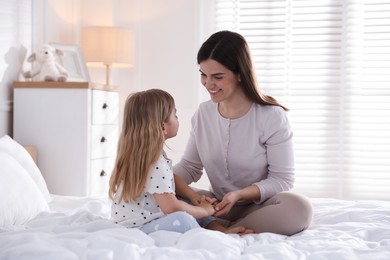 Photo of Mother and daughter on bed at home