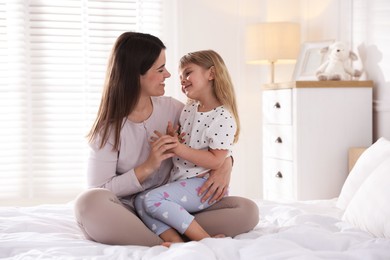 Photo of Mother and daughter on bed at home
