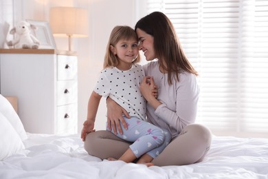 Photo of Mother and daughter on bed at home