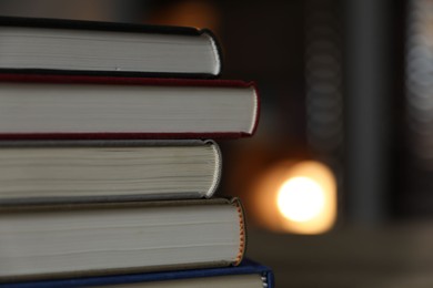 Photo of Stack of books against blurred background, closeup. Space for text
