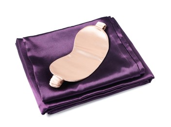 Photo of Silky bed linens and sleeping mask on white background