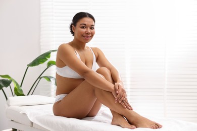Photo of Woman in white underwear with smooth skin after epilation procedure in beauty salon