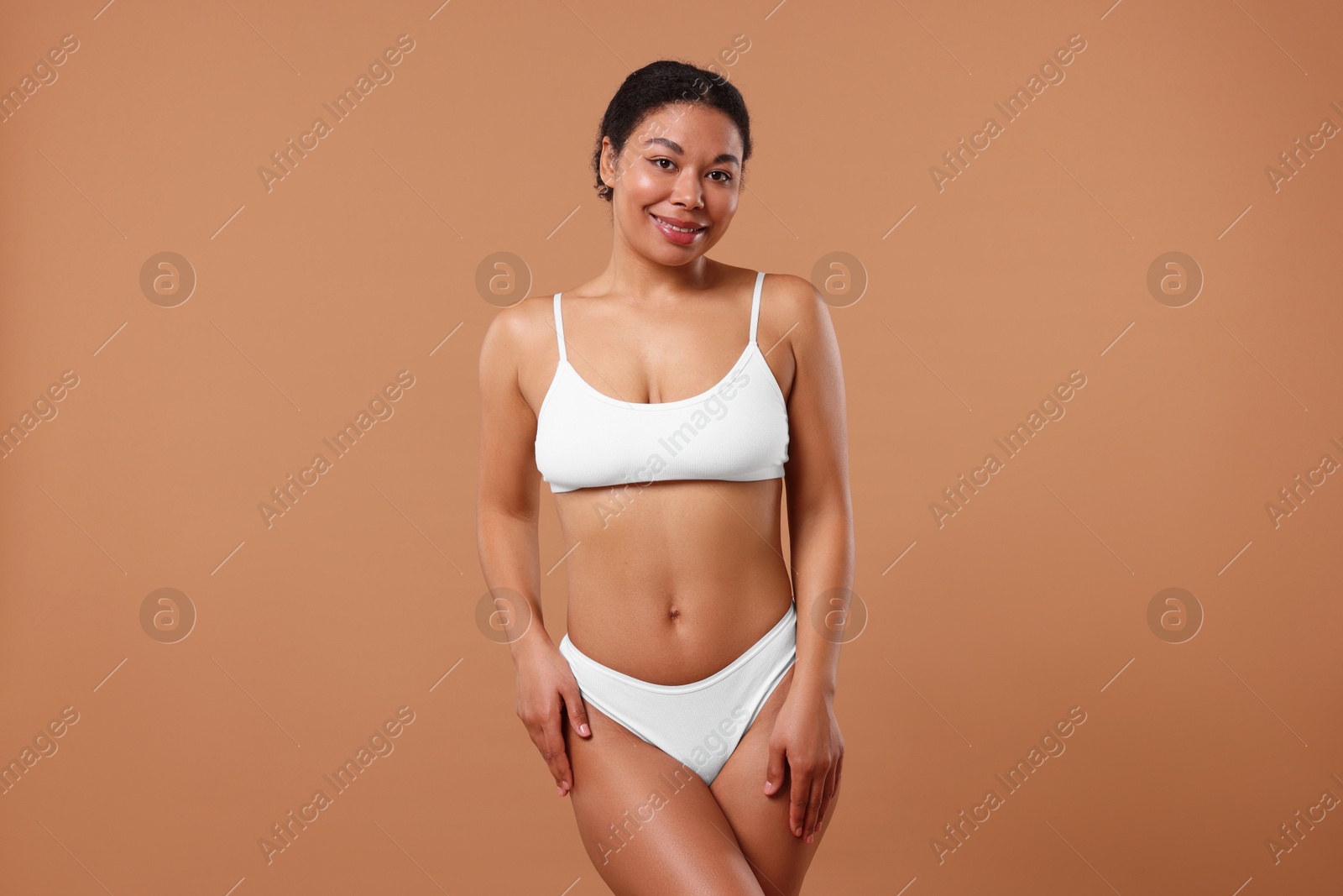 Woman in white underwear with smooth skin after epilation procedure on beige background Photo of Woman in white underwear with smooth skin after epilation procedure on beige background