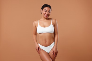 Photo of Woman in white underwear with smooth skin after epilation procedure on beige background