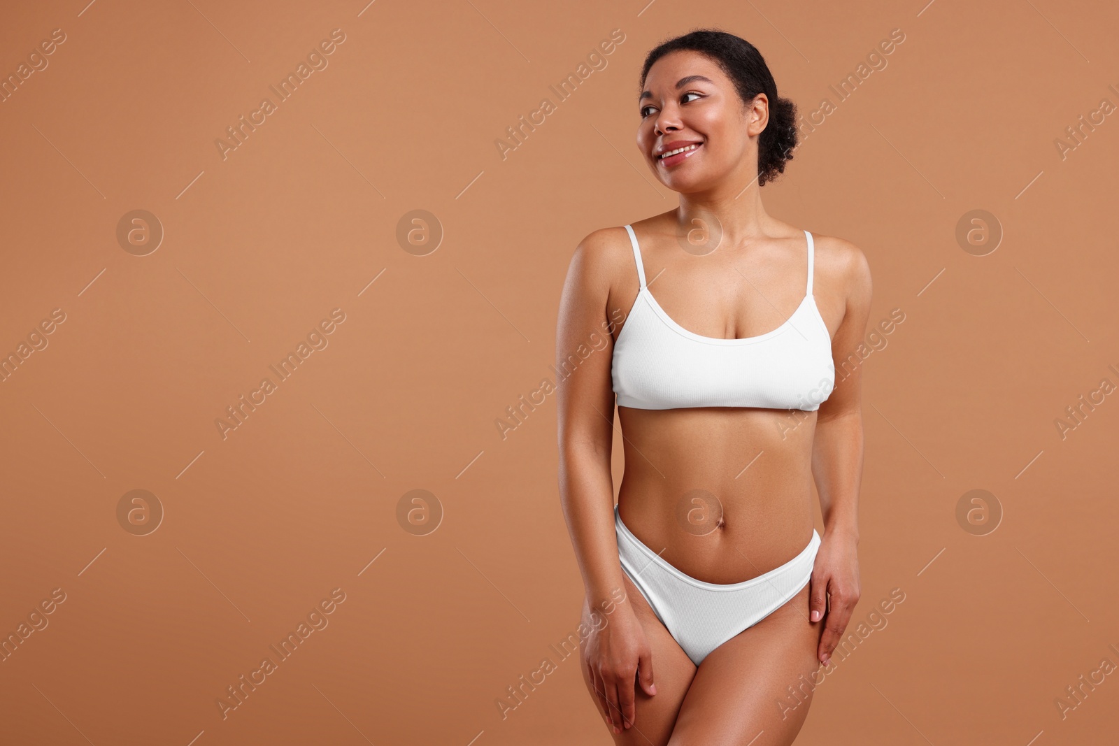 Photo of Woman in white underwear with smooth skin after epilation procedure on beige background, space for text