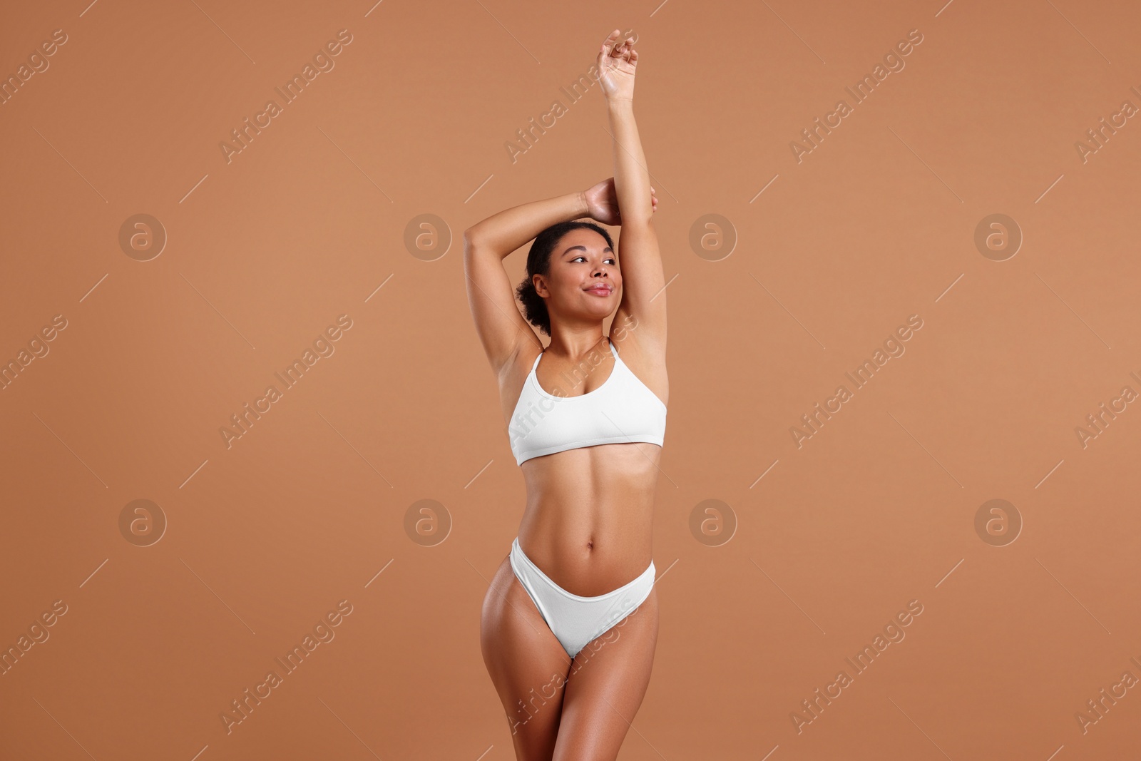 Woman in white underwear with smooth skin after epilation procedure on beige background Photo of Woman in white underwear with smooth skin after epilation procedure on beige background