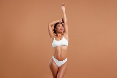 Photo of Woman in white underwear with smooth skin after epilation procedure on beige background