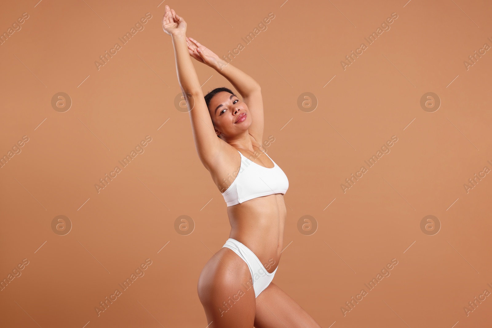 Photo of Woman in white underwear with smooth skin after epilation procedure on beige background