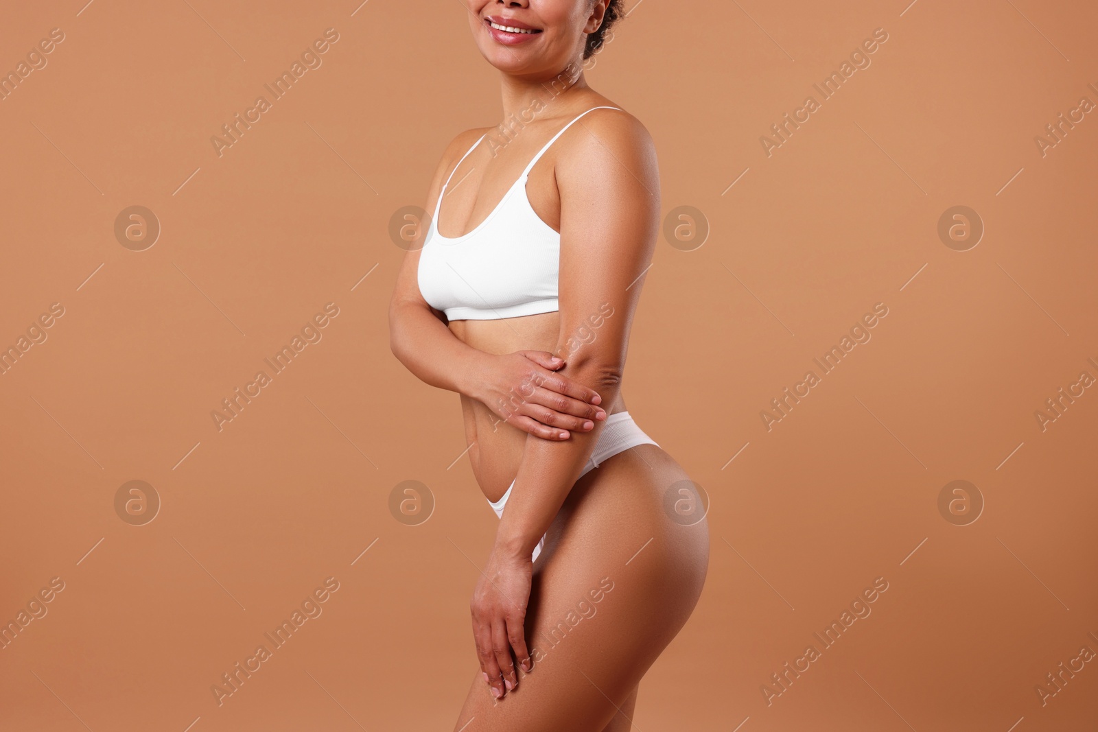 Woman in white underwear with smooth skin after epilation procedure on beige background, closeup Photo of Woman in white underwear with smooth skin after epilation procedure on beige background, closeup