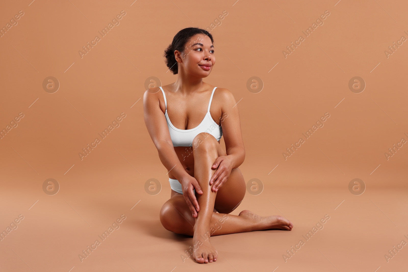 Woman in white underwear with smooth skin after epilation procedure on beige background Photo of Woman in white underwear with smooth skin after epilation procedure on beige background