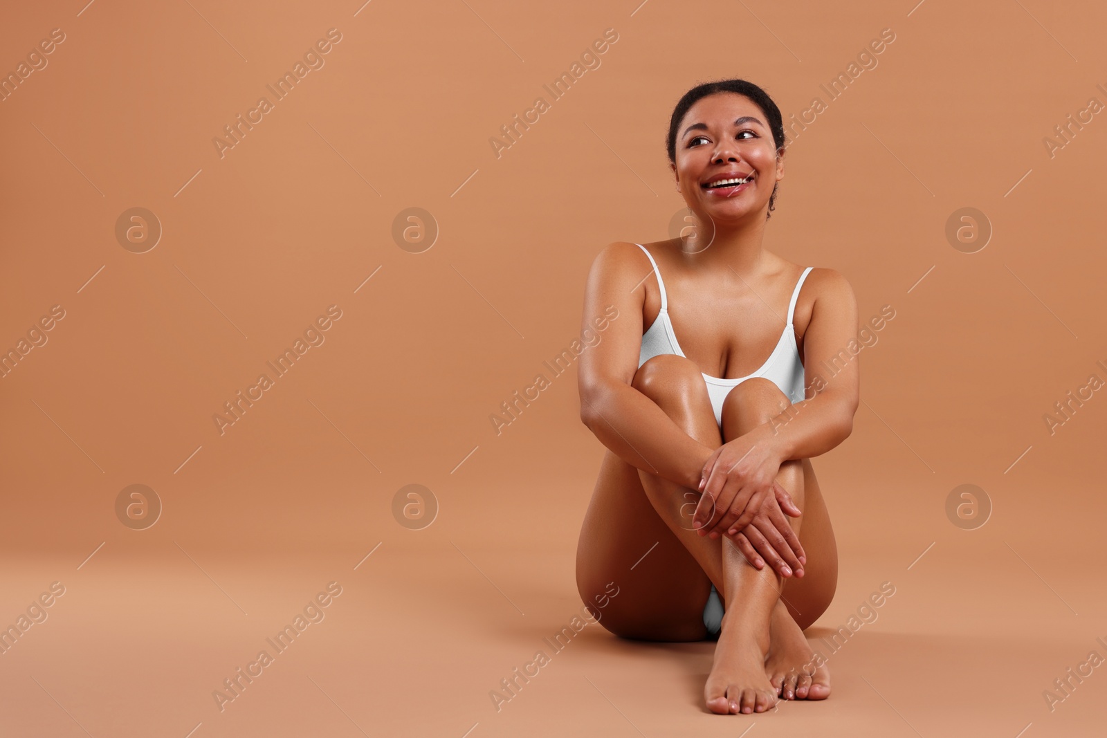 Woman in underwear with smooth skin after epilation procedure on beige background, space for text Photo of Woman in underwear with smooth skin after epilation procedure on beige background, space for text