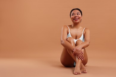 Photo of Woman in underwear with smooth skin after epilation procedure on beige background, space for text