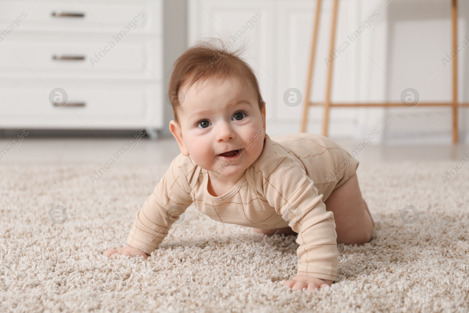 Photo of Cute little baby with rattle toy on floor at home