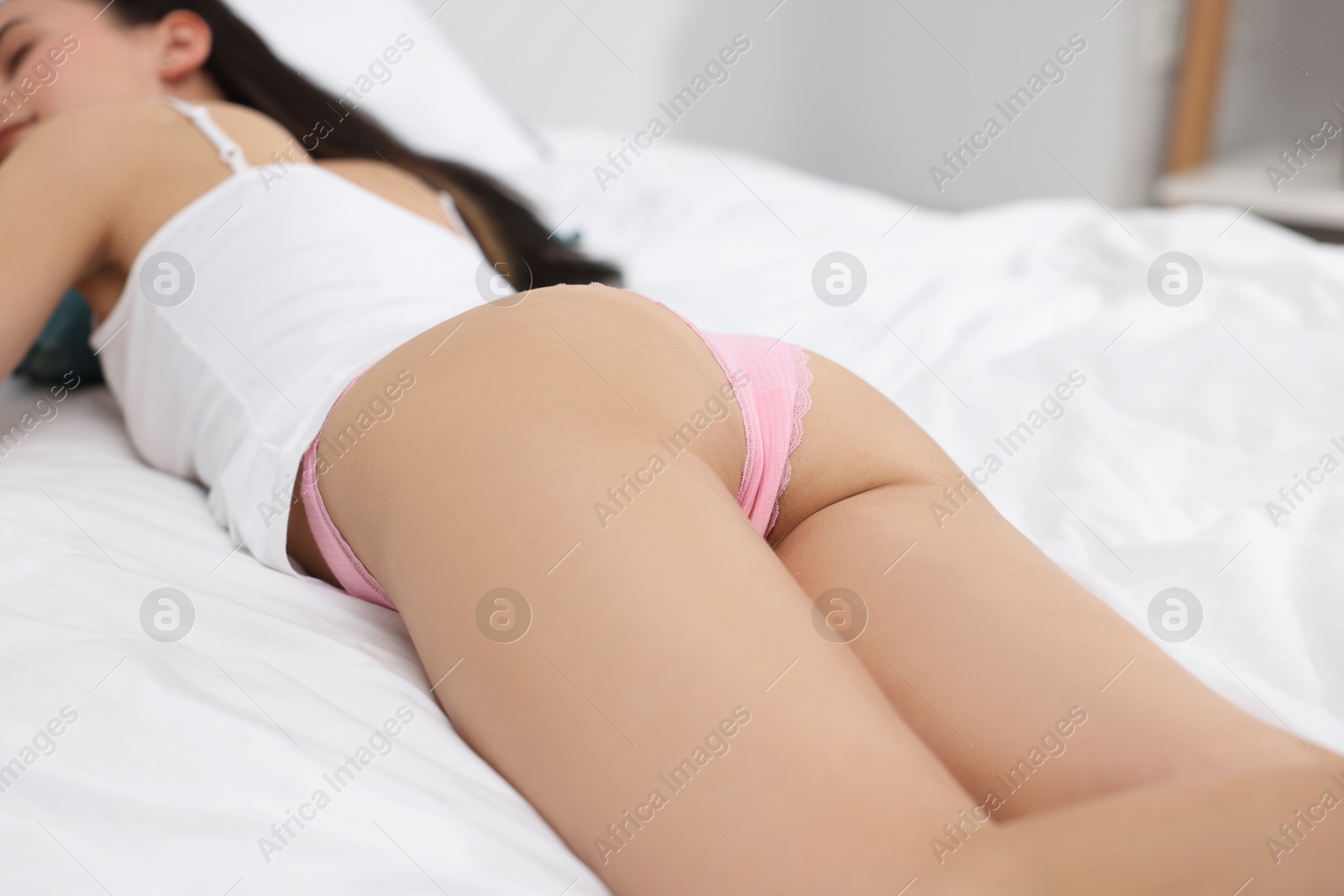 Woman in beautiful underwear lying on bed, closeup Photo of Woman in beautiful underwear lying on bed, closeup