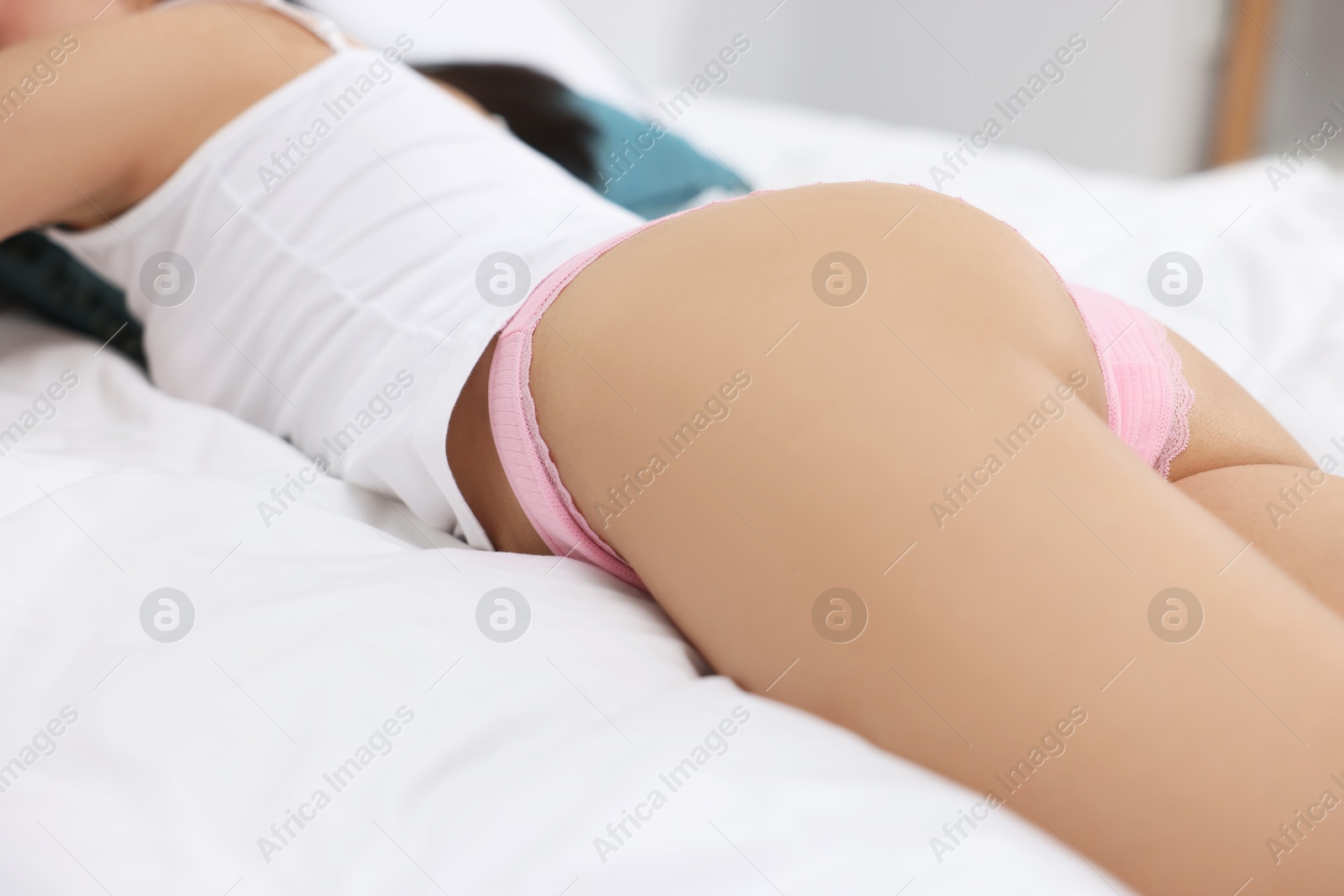 Woman in beautiful underwear lying on bed, closeup Photo of Woman in beautiful underwear lying on bed, closeup