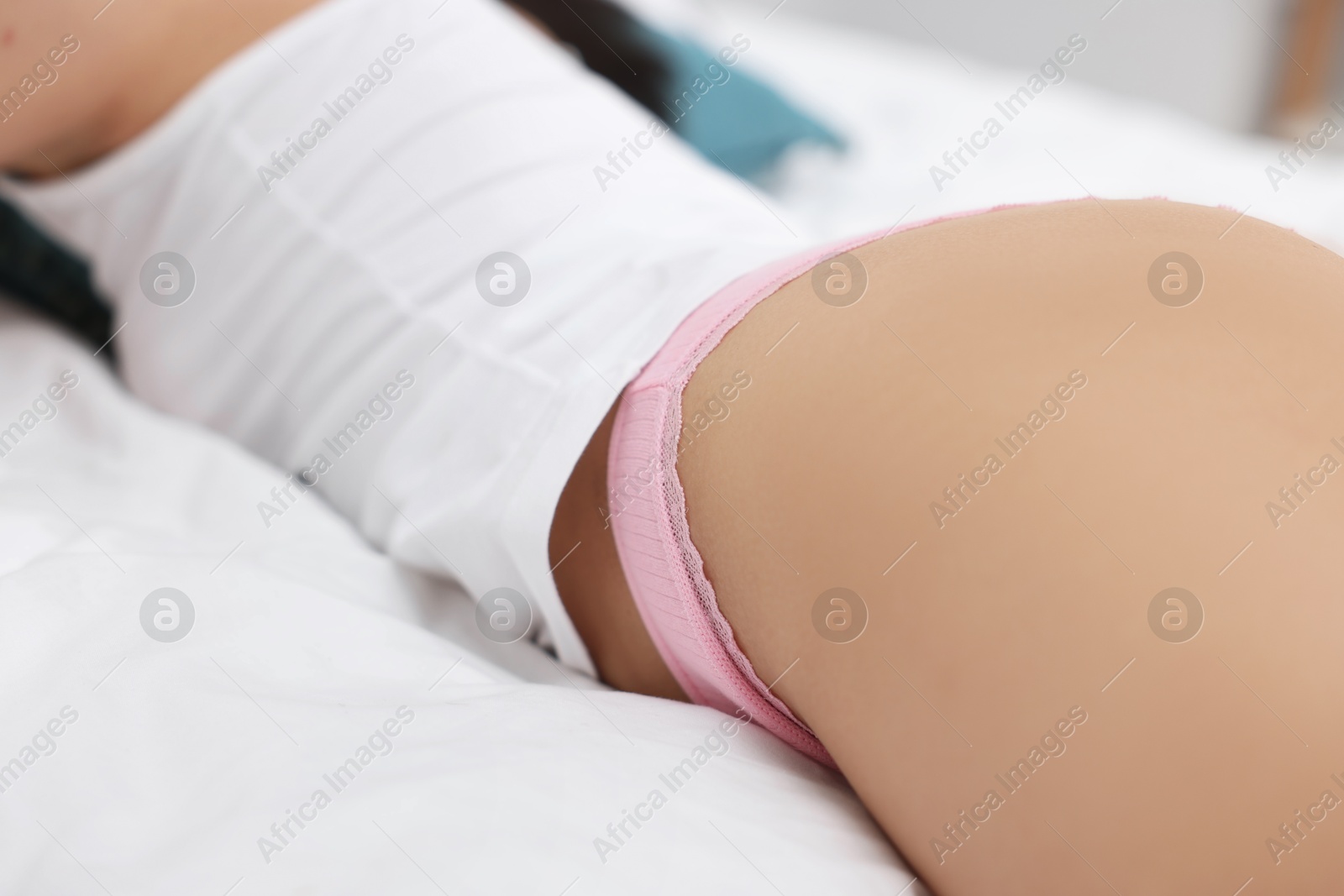 Woman in beautiful underwear lying on bed, closeup Photo of Woman in beautiful underwear lying on bed, closeup