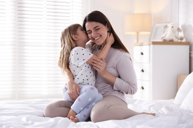 Photo of Mother and daughter on bed at home