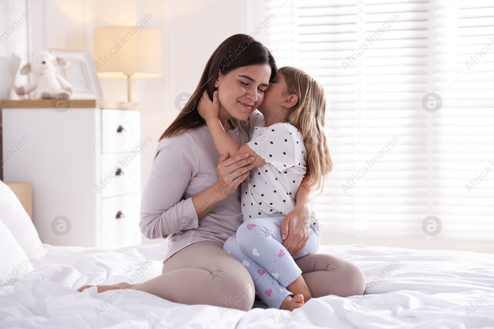 Mother and daughter on bed at home Photo of Mother and daughter on bed at home