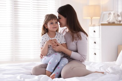 Photo of Mother and daughter on bed at home