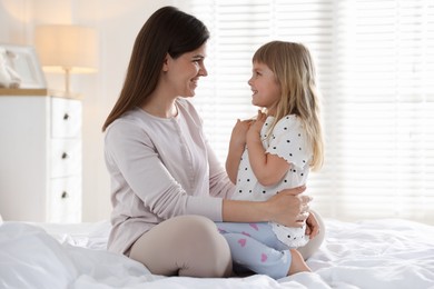 Photo of Mother and daughter on bed at home