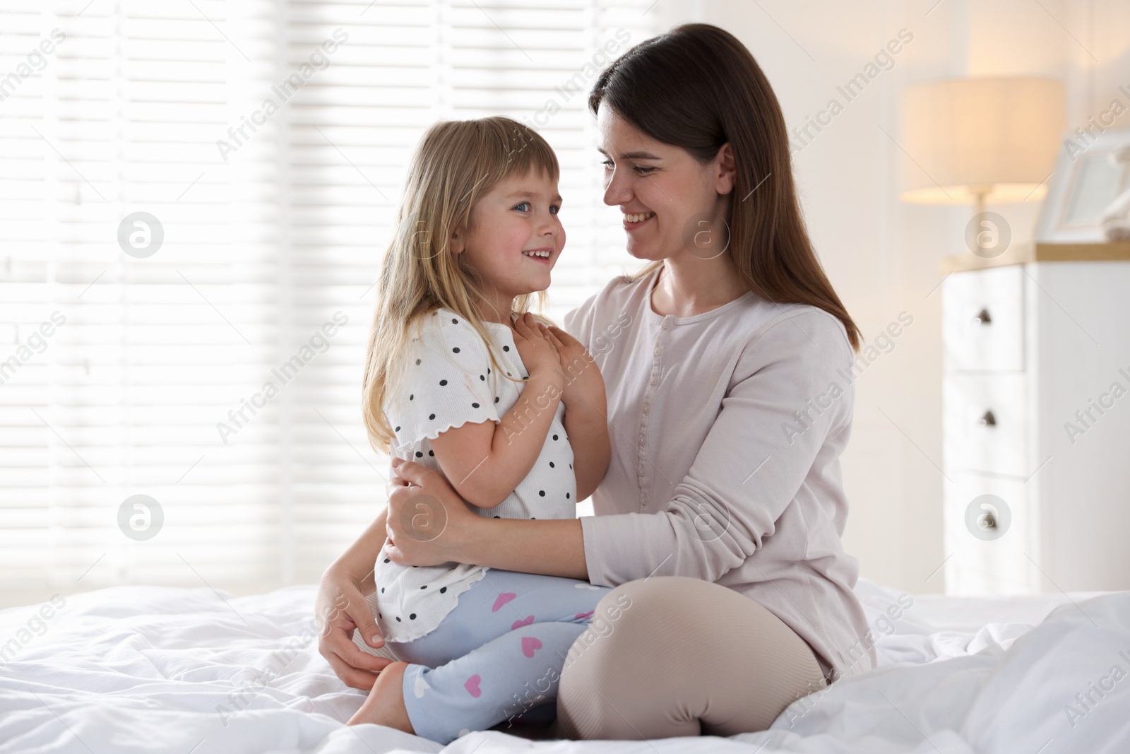 Mother and daughter on bed at home Photo of Mother and daughter on bed at home