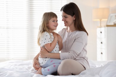 Photo of Mother and daughter on bed at home