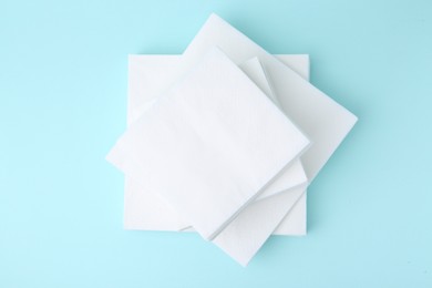 Photo of Stack of disposable paper handkerchiefs on light blue background, top view