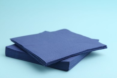 Photo of Stack of disposable paper handkerchiefs on light blue background, closeup