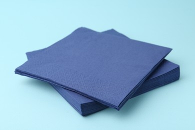Photo of Stack of disposable paper handkerchiefs on light blue background, closeup