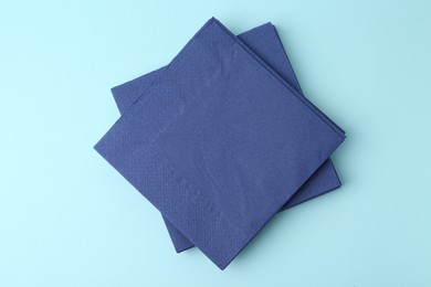 Photo of Stack of disposable paper handkerchiefs on light blue background, top view