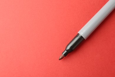Photo of One color marker on red background, top view. Space for text