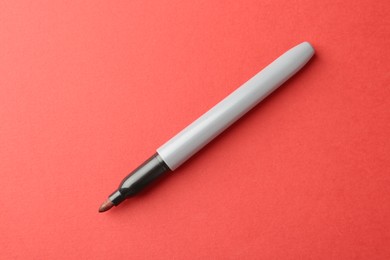 Photo of One color marker on red background, top view. Space for text