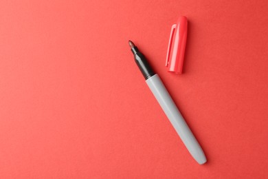 Photo of One color marker on red background, top view. Space for text