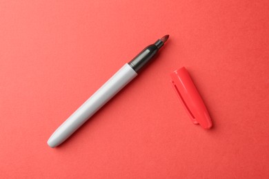 Photo of One color marker on red background, top view