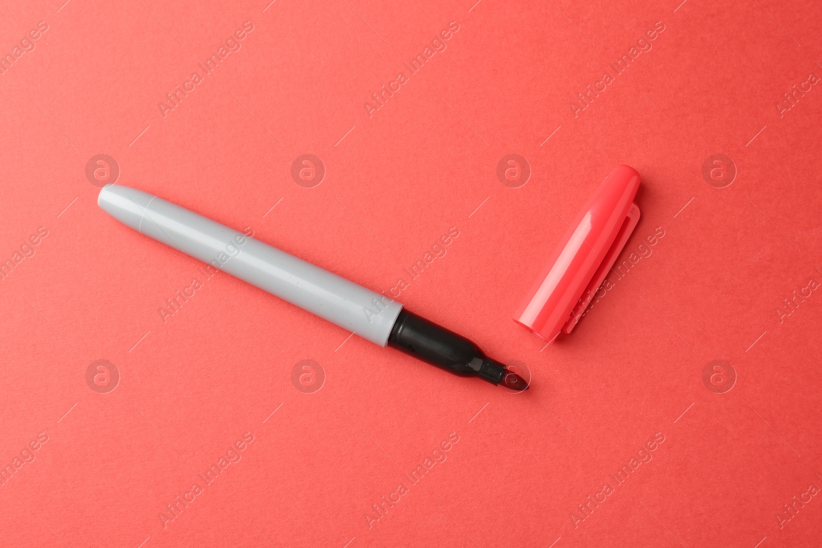 One color marker on red background, top view Photo of One color marker on red background, top view