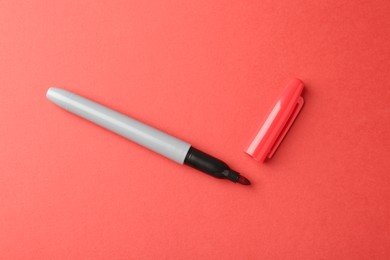 Photo of One color marker on red background, top view