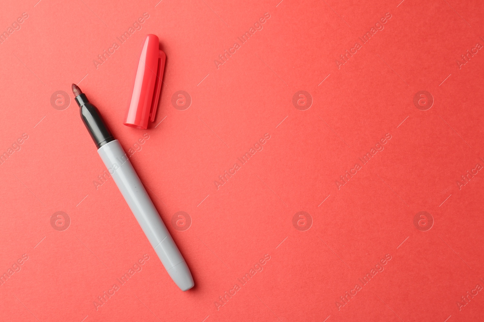 One color marker on red background, top view. Space for text Photo of One color marker on red background, top view. Space for text