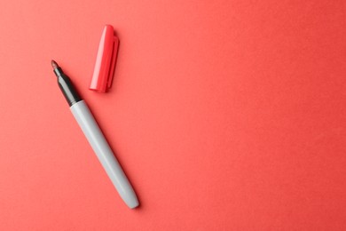 Photo of One color marker on red background, top view. Space for text
